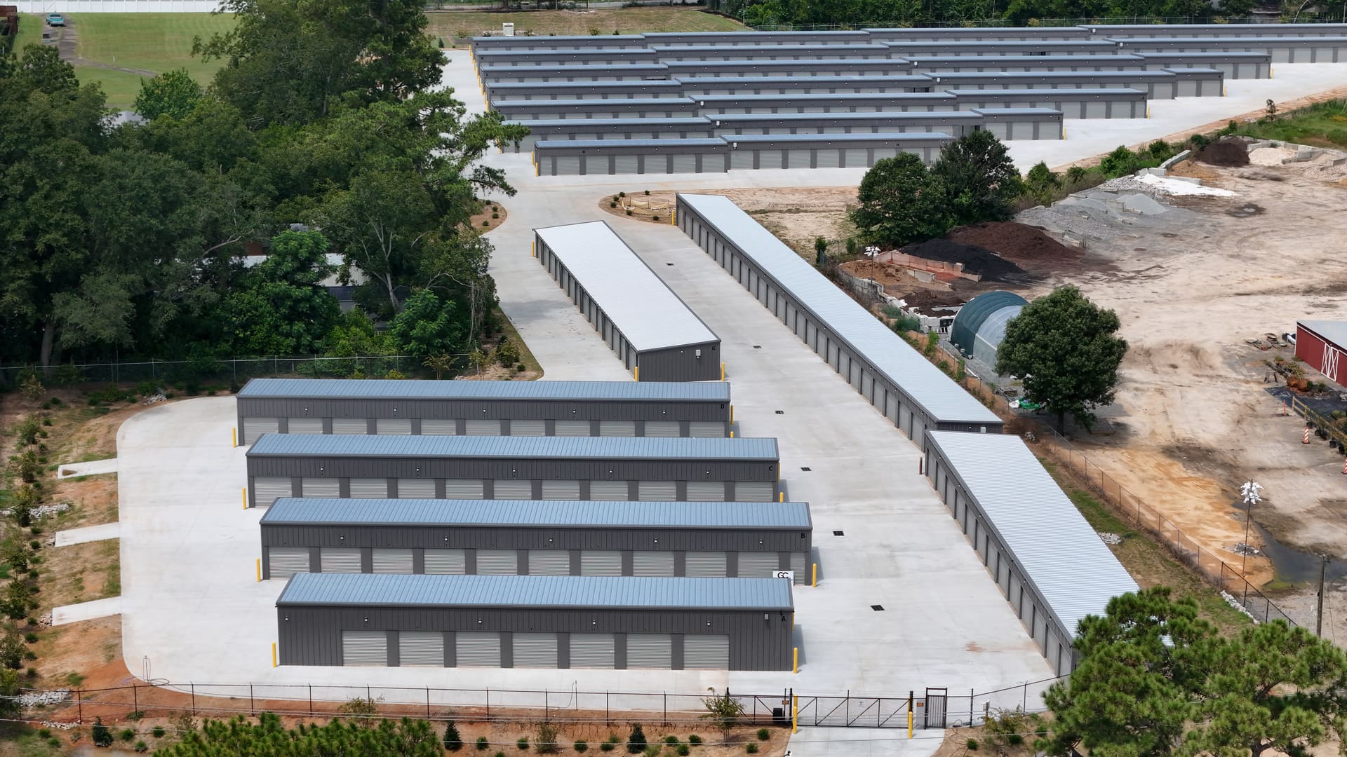 A close aerial view of one building at My Storage, showing a row of individual grey roll-up doors under a white metal roof.