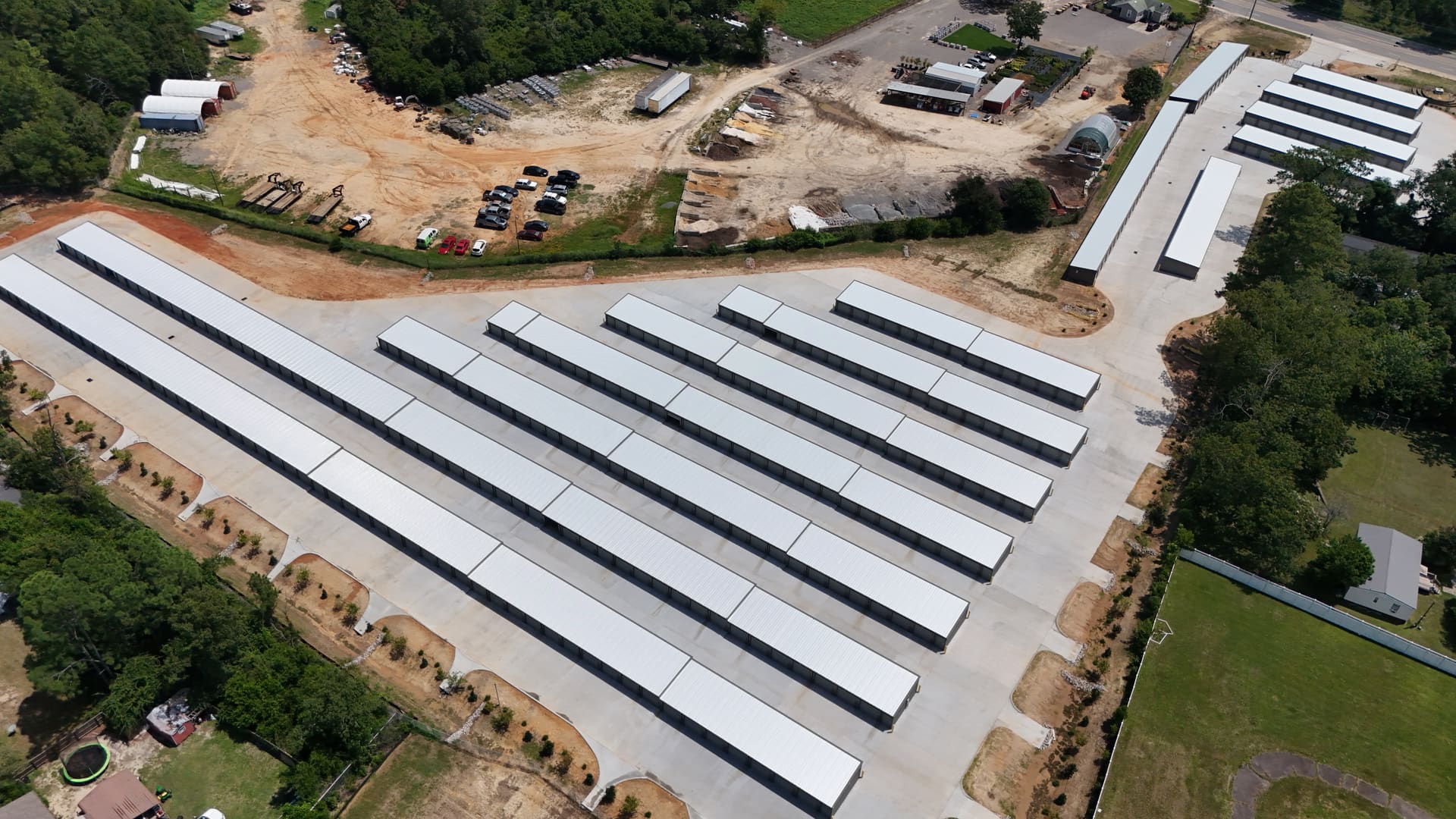 My Storage seen from almost directly above: parallel rows of storage buildings on new concrete, the drive aisles running between them, and the fence line around the whole site.